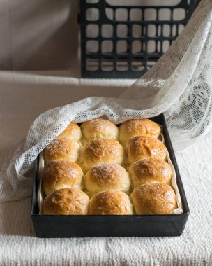 Ev yapımı ekmek ruloları, keten masa örtüsünün üzerinde teneke kalıplar. Seçici odak