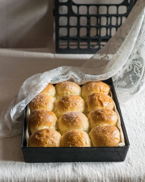 Ev yapımı ekmek ruloları, keten masa örtüsünün üzerinde teneke kalıplar. Seçici odak
