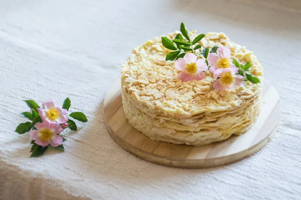 薄い織物の背景に花で飾られた全体の層状ナポレオンケーキ 選択的な焦点 — ストック写真