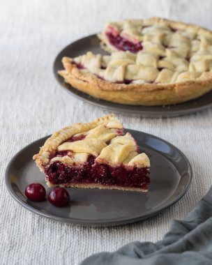 Açık keten arka planda gri tabakta vişneli pasta, seçici odak