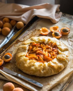 Fransız Galerisi ya da ahşap arka planda, olgun kayısılı bir turta, seçici bir odak noktası. Yaz ev yapımı tatlı hamur işleri