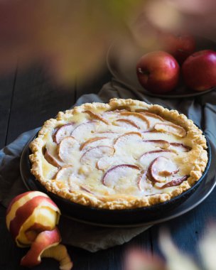 Siyah masada olgun kırmızı elmalı kremalı turta, seçici odaklı.