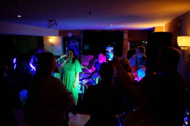 The Sub Tones 'da, Anchor Inn' deki Sutton Bridge Spalding barında renkli ışıklandırmayla şarkı söyleyen bir kadın şarkıcı. Hughnshire