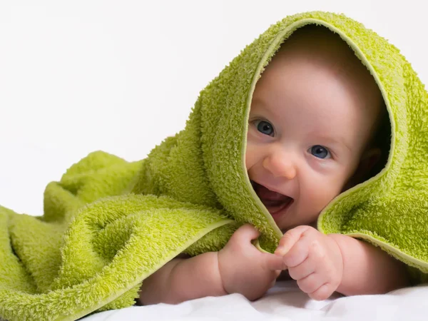 Alegre sorrindo bebê menina em uma toalha — Fotografia de Stock