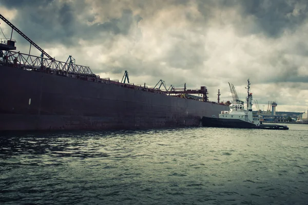 Tugboat pushing a ship — Stock Photo, Image