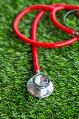 Yeşil çimlerde kırmızı steteskop 