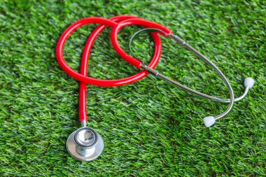 Yeşil çimlerde kırmızı steteskop 