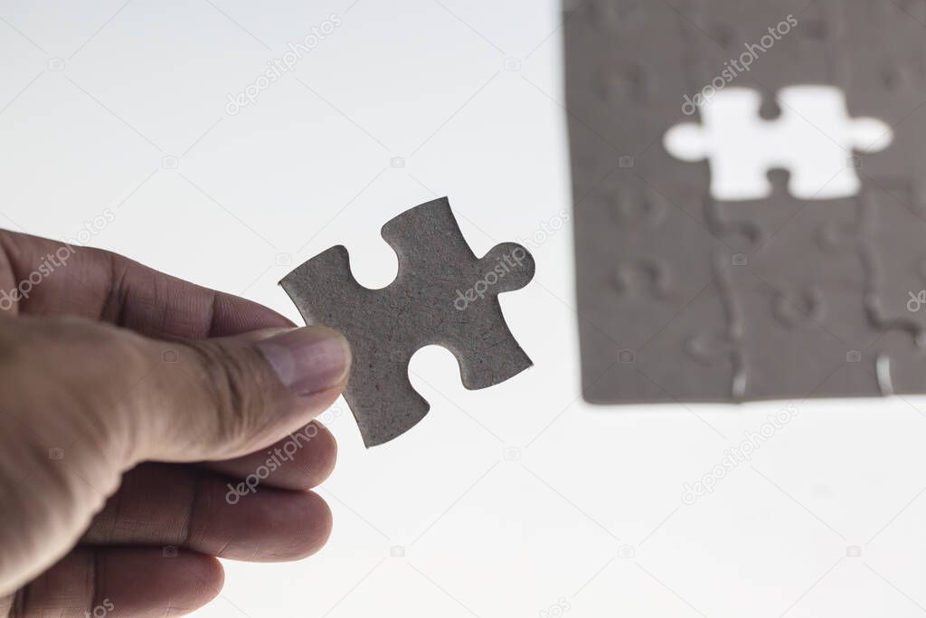 jigsaw puzzle in hand on white background