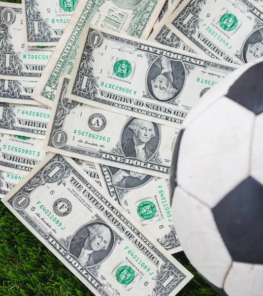  Çimlerin üzerinde dolar banknotları olan futbol topu
