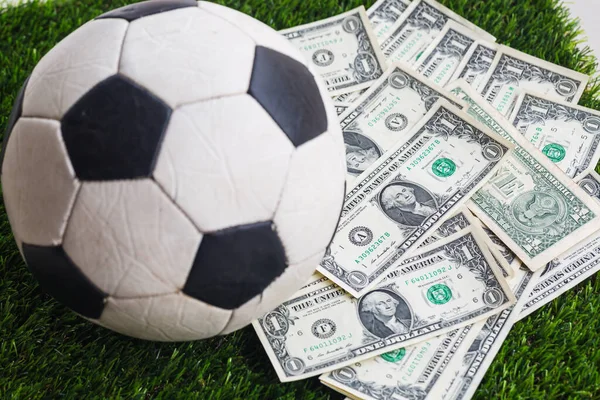  Çimlerin üzerinde dolar banknotları olan futbol topu