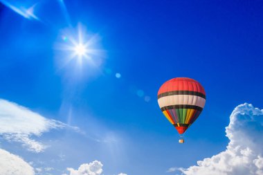 Açık mavi gökyüzünde yüzen sepetli balonun fotoğrafı 