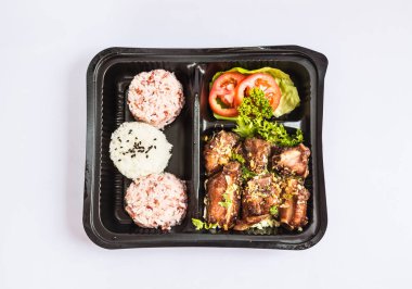 Kızarmış tavuk göğsü, beyaz arka planda pirinç ve sebze.