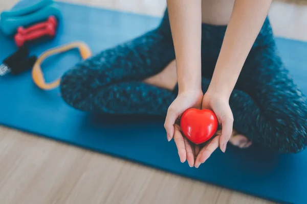 Een Yoga Vrouw Houdt Een Rood Hart Vast Stockfoto