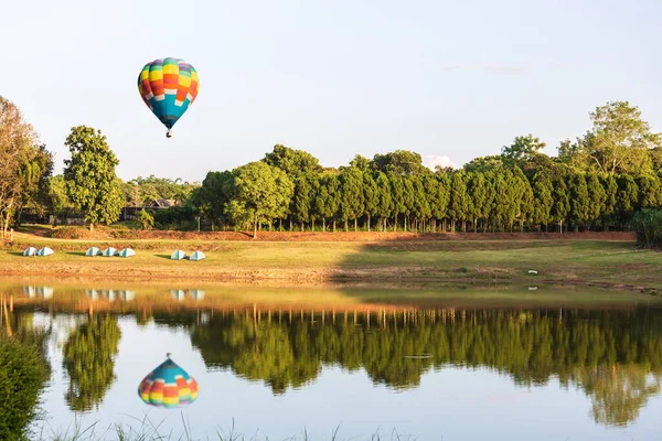 color hot air balloon in sky over the lake water, holiday concept.