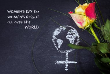 Rose and a chalk drawn female sign with earth globe on a blackboard, concept womens rights, sample text clipart