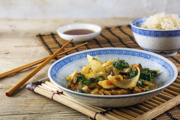 Asian vegetable dish with  rice and soy sauce on a bamboo mat and rustic wood — Stock Photo, Image
