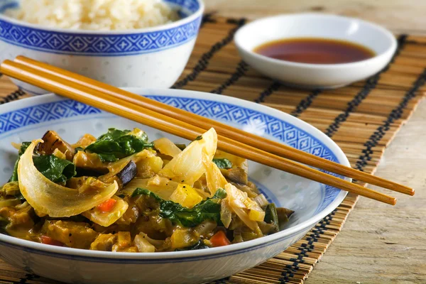 Asiatisches Gemüsegericht mit Essstäbchen auf Bambusmatte und rustikalem Holz, Nahaufnahme — Stockfoto