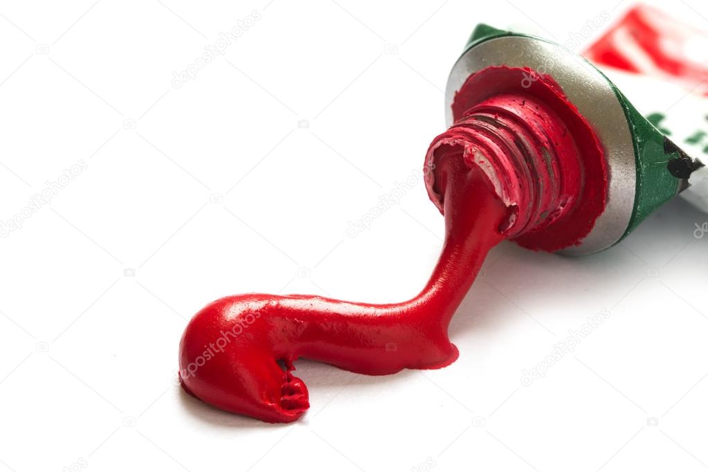 red paint color runs out of the tube, closeup isolated on white,