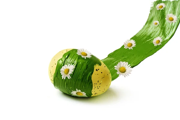 Œuf de Pâques roule à travers un trait de couleur verte avec marguerites isolées sur blanc — Photo