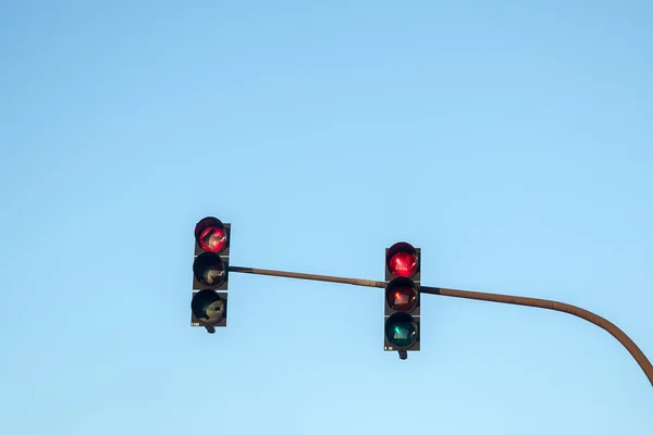 Semáforos mostrando vermelho em todas as direções contra o sk azul — Fotografia de Stock