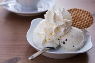 krem şanti ve bisküvi bir kasede vanilyalı dondurma topla 