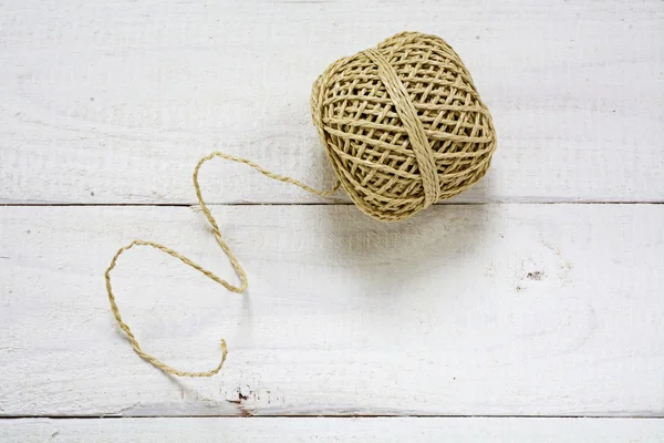 Palla di corda con trama e fili su uno sfondo di legno verniciato bianco — Foto Stock