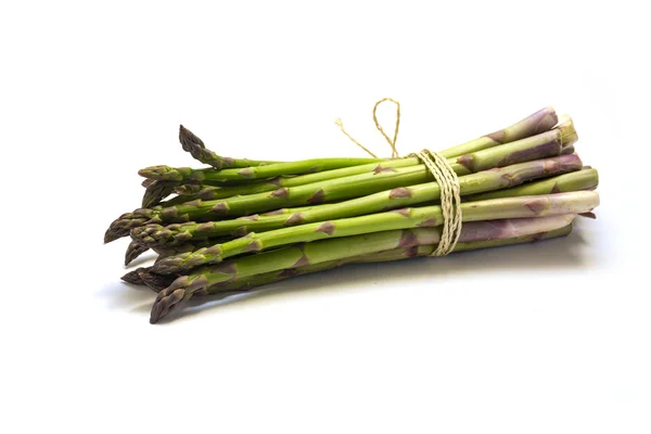 Bos van groene asperges geïsoleerd met schaduw op een witte achtergrond — Stockfoto