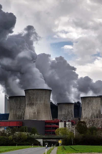 Dampfende Kühltürme eines Kraftwerks mit dunkelgrauer Emission — Stockfoto