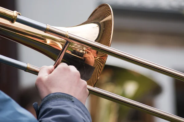 Trombone speler uit een messing orkest met reflectie in de muziekinstrument — Stockfoto