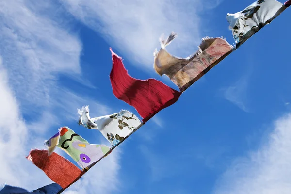 Homemade  bunting triangular flags fluttering in the wind against a blue sky with clouds — Stock Photo, Image