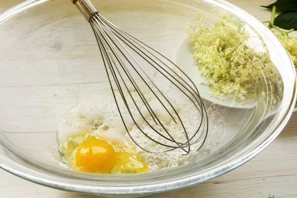 Making pancake batter for sweet fried elderflowers, bowl with  ingredients and whisk — Stock Photo, Image