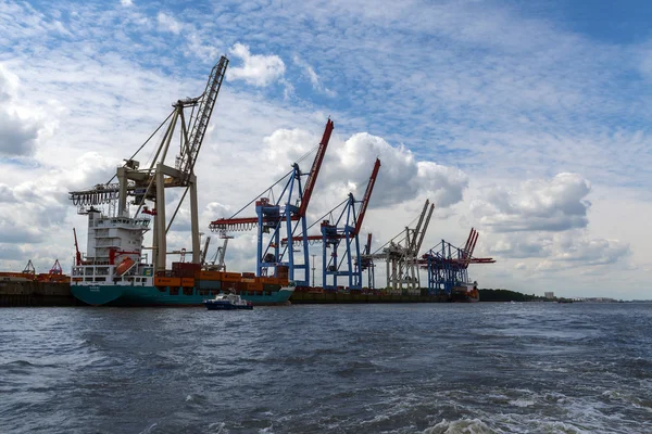 Hamburgo, Alemanha - 11 de junho de 2016: guindastes e um navio porta-contentores no porto internacional de carga de Hamburgo — Fotografia de Stock