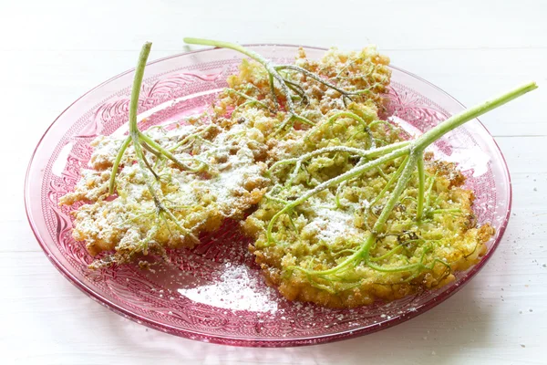 Stekt fläder pannkakor med florsocker på en rosa glasskål — Stockfoto