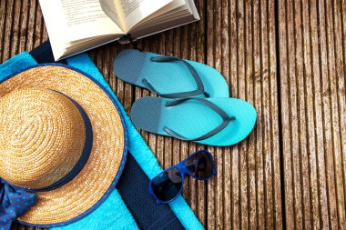 yaz tatili, plaj tatil için aksesuarlar ve rustik ahşap yaya köprüsü üzerine bir kitap