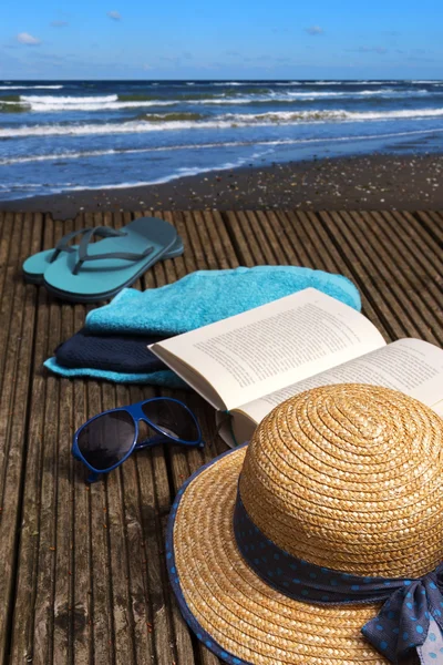 Vacaciones de verano en la orilla del mar, accesorios para vacaciones de playa en una plataforma de baño de madera directamente en el mar —  Fotos de Stock