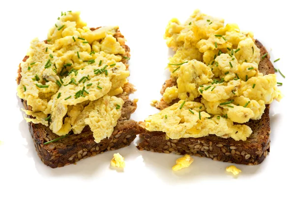 Scrambled eggs on rustic wholemeal bread, isolated on white — Stock Photo, Image