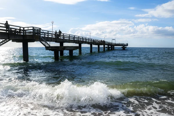 Pier Beach v mořské vlny proti modré obloze na pobřeží Baltského moře v Reriku, Německo — Stock fotografie