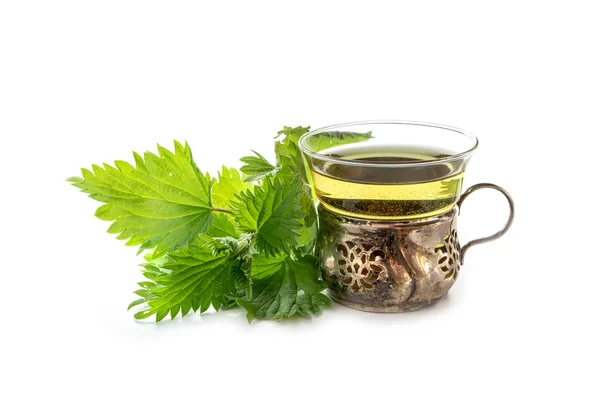 Vintage teacup of glass and silver with nettle tea and some fresh leaves, isolated on white — Stock Photo, Image