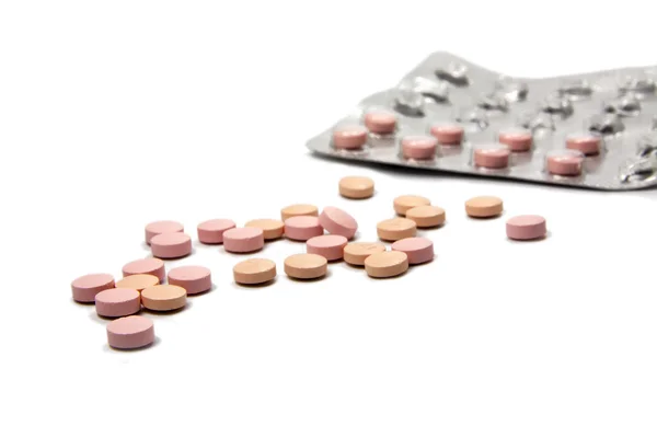 Pillole rosa e blister isolati con ombre su un bac bianco — Foto Stock