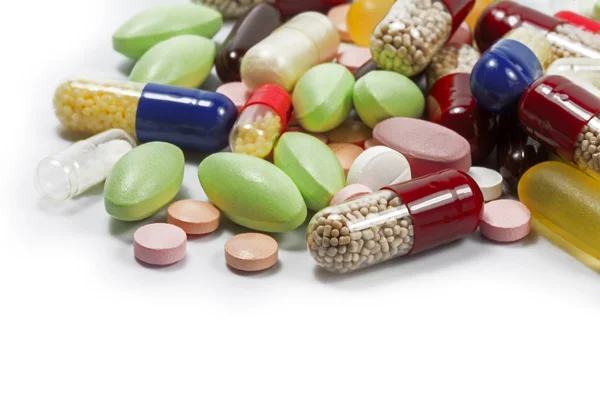 Pillole colorate e capsule mediche come sfondo angolo isola — Foto Stock