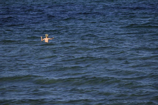 Pieni poika lapsi kylpee iso sininen meri, antelias kopio tilaa, kopioi tilaa — kuvapankkivalokuva