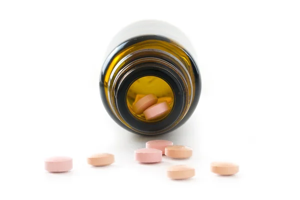 Vista frontale in un flacone di farmacia e le ultime pillole rosa isol — Foto Stock