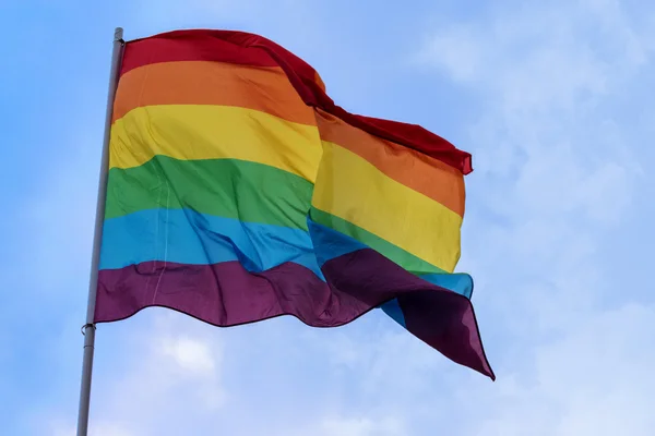 Bandera del arco iris contra el cielo azul, símbolo de tolerancia y aceptación —  Fotos de Stock