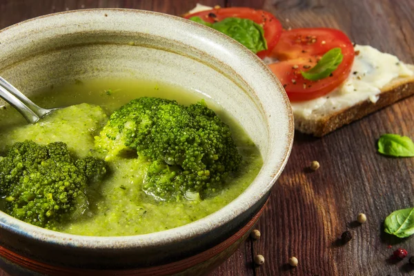 Sopa de verduras de brócoli verde y pan de tomate como guarnición en una mesa de madera rústica — Foto de Stock