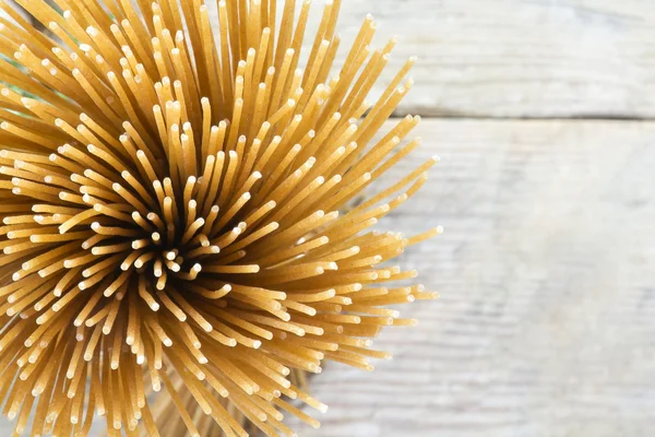 Bunch of wholegrain spaghetti from above on a blurry background — Stock Photo, Image