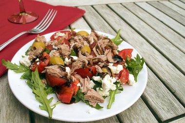 ton balıklı salata domates, zeytin ve roka ahşap Bahçe masa üzerinde