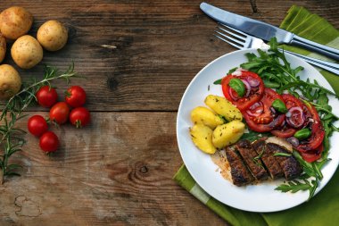 sığır fileto mignon patates ve domates Roka Salatası ile kopya alanı bir rustik ahşap tahtada ile kavrulmuş