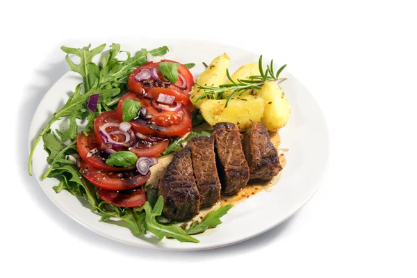 Жареная говядина филе миньон с картошкой и салатом из рукколы на белом фоне — стоковое фото
