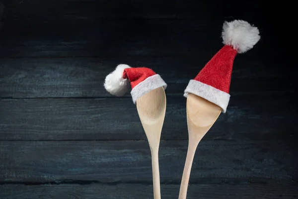 Two Cooking Spoons Red Santa Claus Hats Dark Blue Wooden — Stock Photo, Image