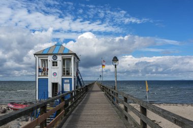 LUBMIN, GERMANY, SEPTEMBER 05, 2020: Sea-bridge with lifeguard station house under a blue sky with clouds, seaside tourist resort for beach holidays at the Baltic Sea in Mecklenburg-Western Pomerania, Germany, copy space clipart